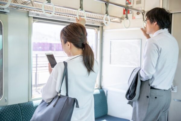 立って電車に乗る男女